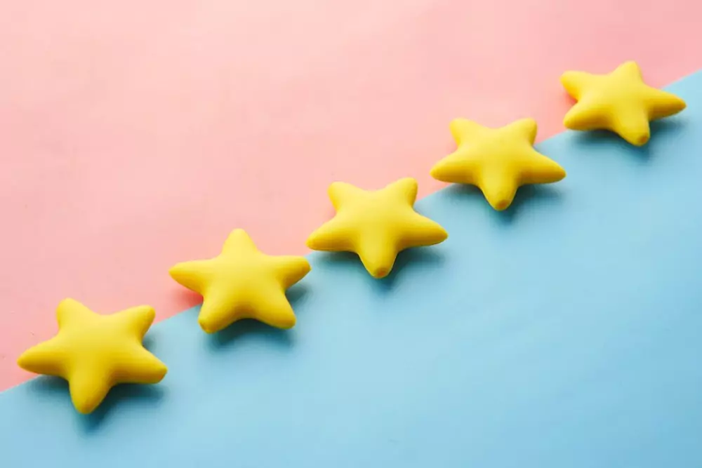 Five yellow stars on a blue and pink background