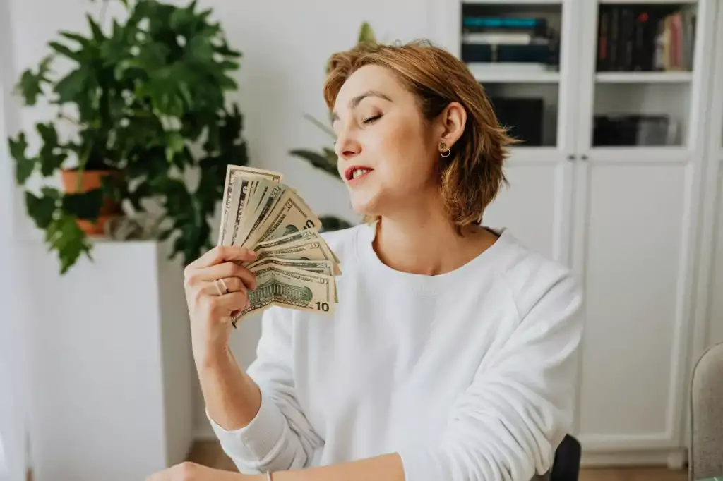 Woman fanning herself with a stack of bills