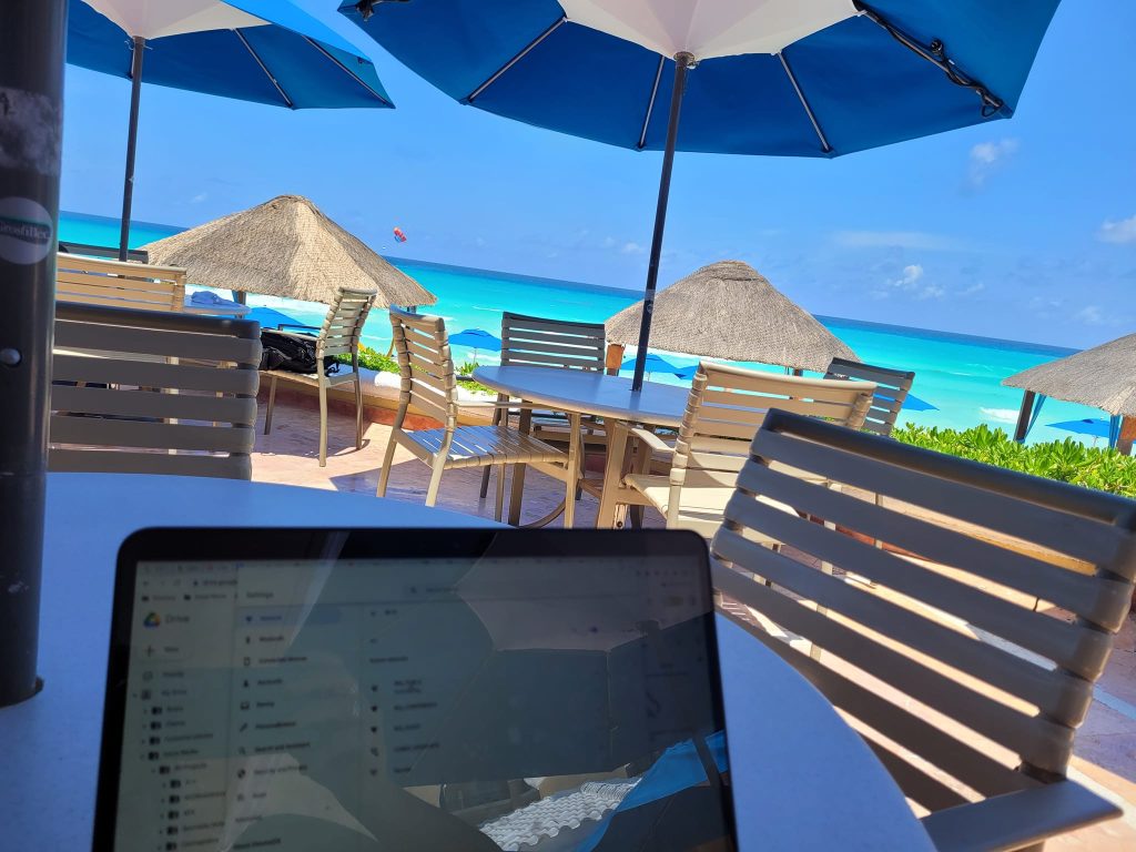 imae of a laptop on the ritz carlton patio in cancun with view of the sea